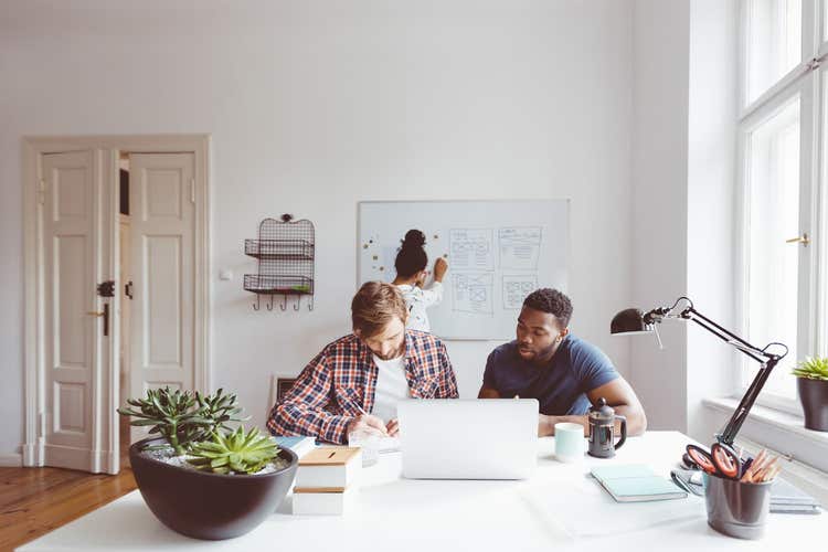 trois personnes travaillant sur un projet