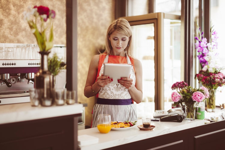 Propriétaire de café regardant la tablette