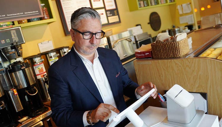 Propriétaire d'entreprise appuyant sur l'écran du point de vente Clover Station