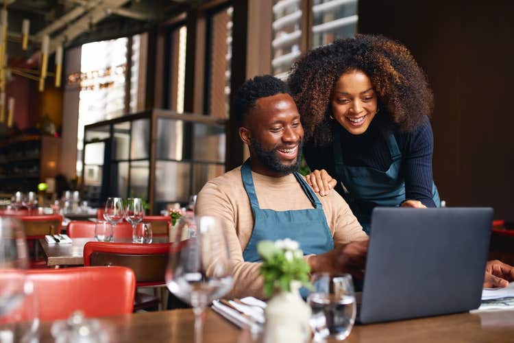 Les partenaires commerciaux de Clover utilisent un ordinateur portable à l'intérieur d'un restaurant