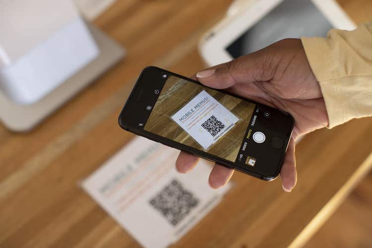 Personne scannant un code QR avec un téléphone intelligent