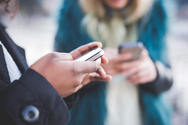 deux personnes regardant des téléphones intelligents