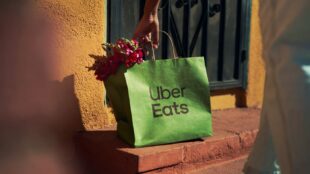 Un sac Uber Eats vert sur le pas de la porte.