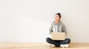 Femme assise, jambes croisées, avec un ordinateur portable