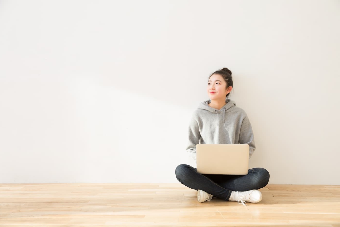 Femme assise, jambes croisées, avec un ordinateur portable