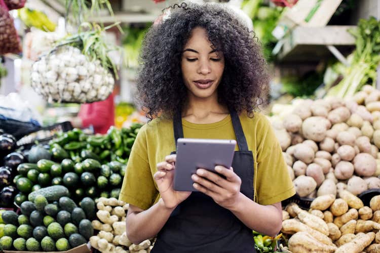 Woman in grocery store looking at tablet