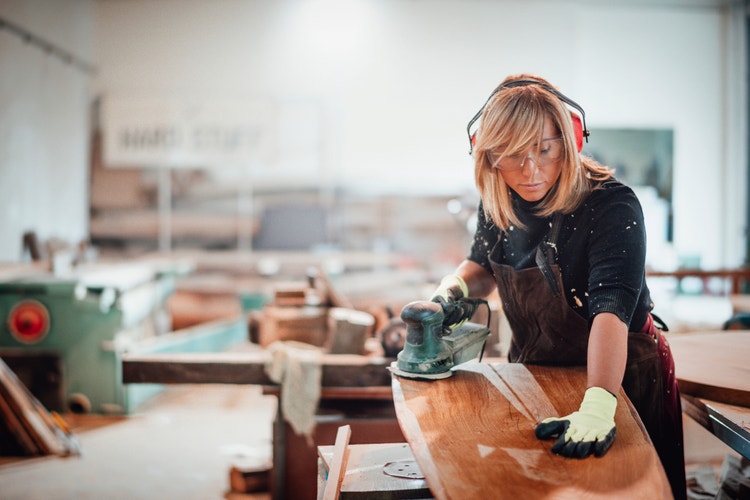 Small business owner - woman using woodworking machine