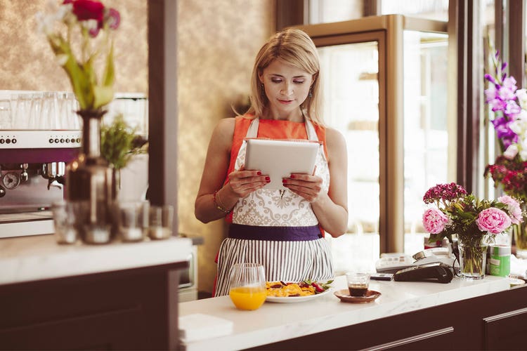Café owner looking at tablet