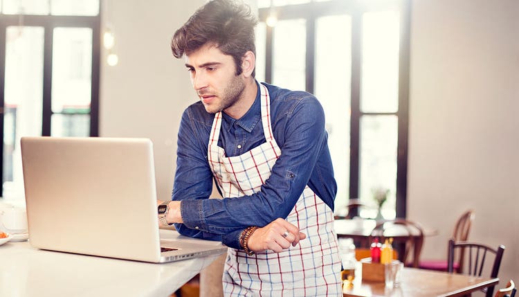 Restaurant server looking at laptop