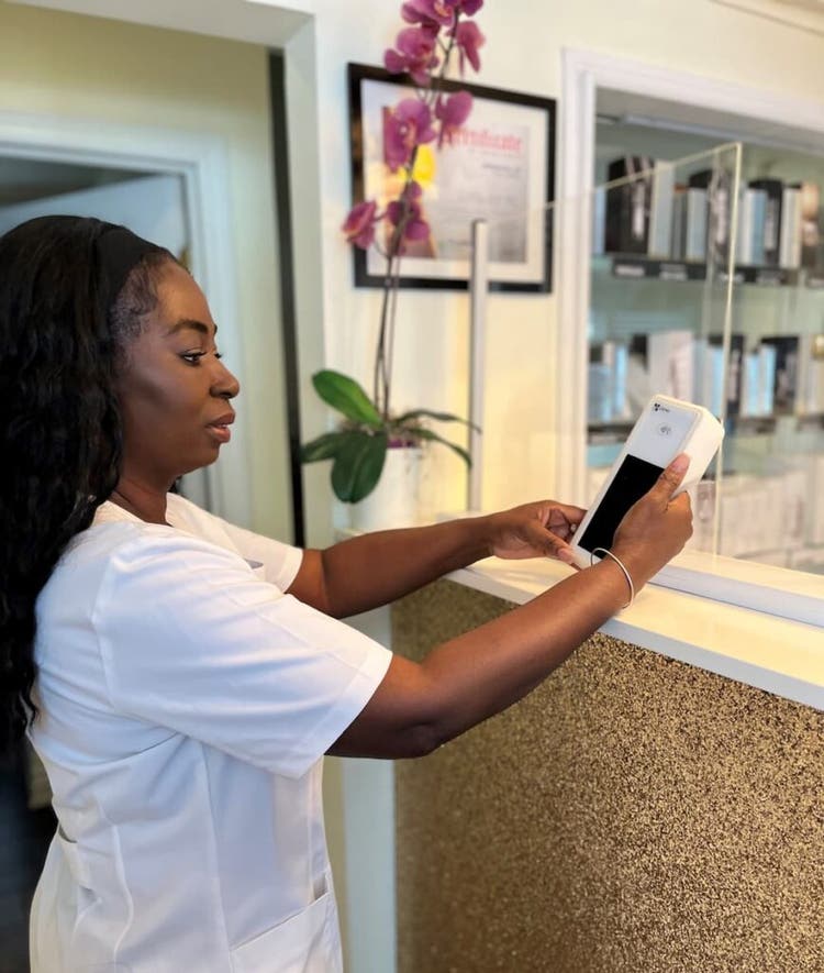 Ann Marie, owner of La Peau D'or Beauty Wellness Spa holding the Clover Flex
