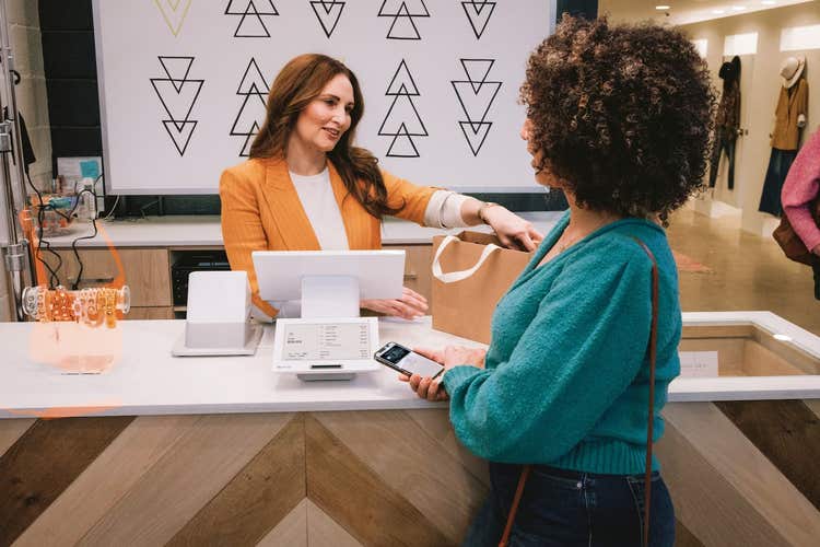 Woman making payment at a retail store on a Clover Station Duo POS