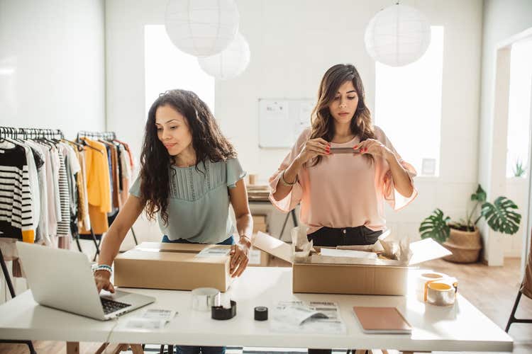 Two women packaging retail merchandise