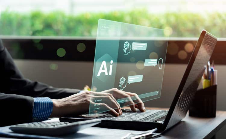 Person using a laptop, viewing a futuristic AI screen.