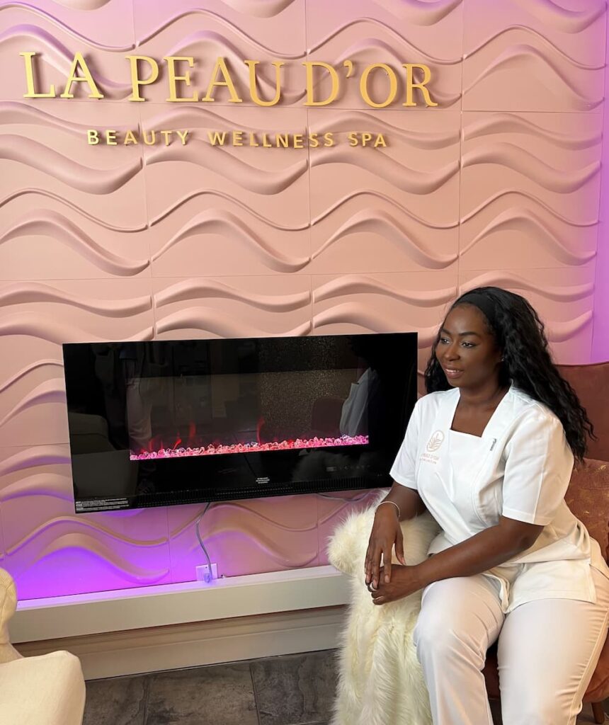 Ann Marie, owner of La Peau D'or Beauty Wellness Spa sitting at fireplace