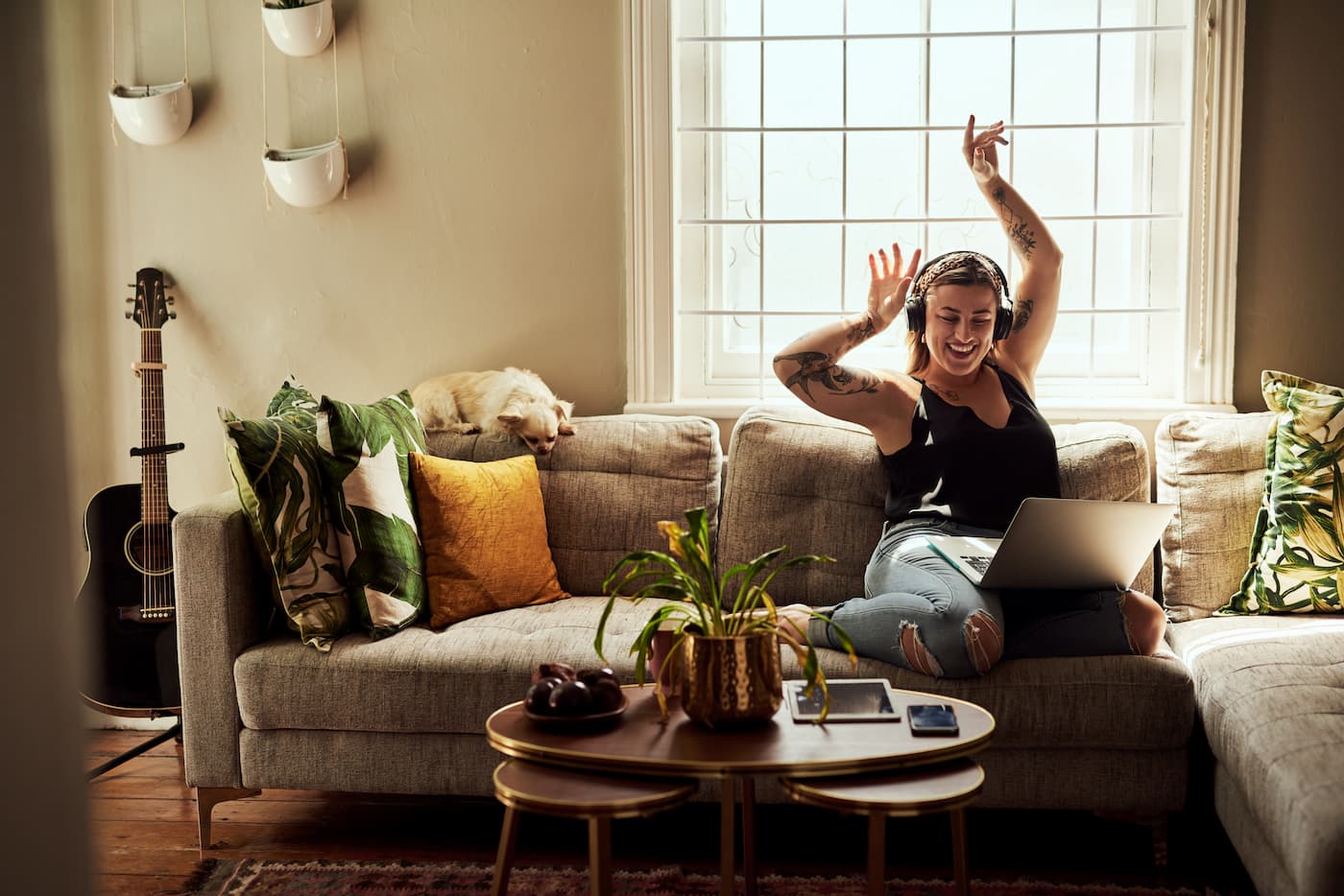 Woman listening to music with headphones in her living room.