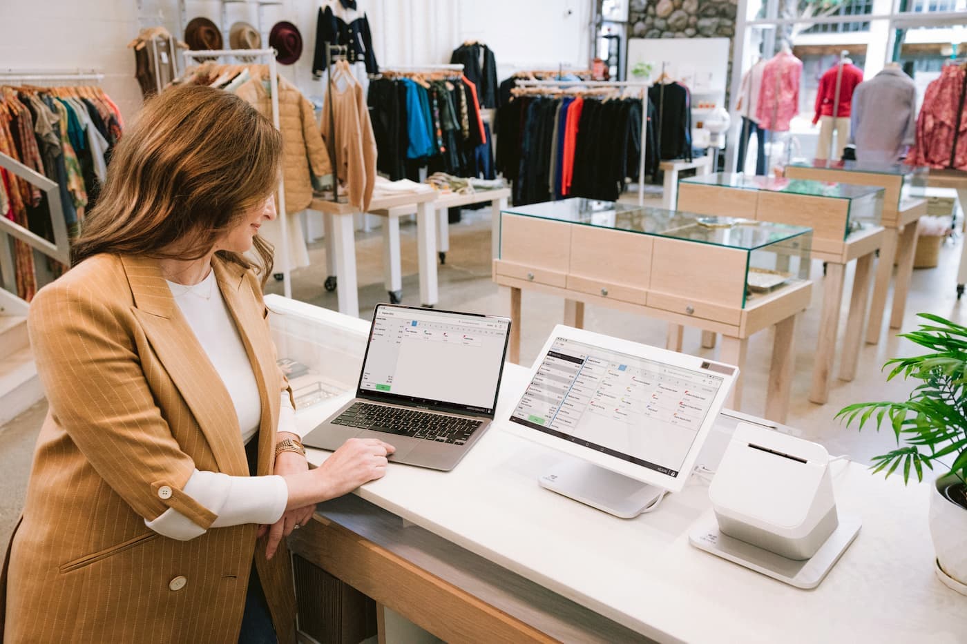 Business owner inside retail boutique using a Clover Station Duo Point-of-Sale system.