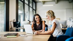 Two women sitting working together in a corporate office