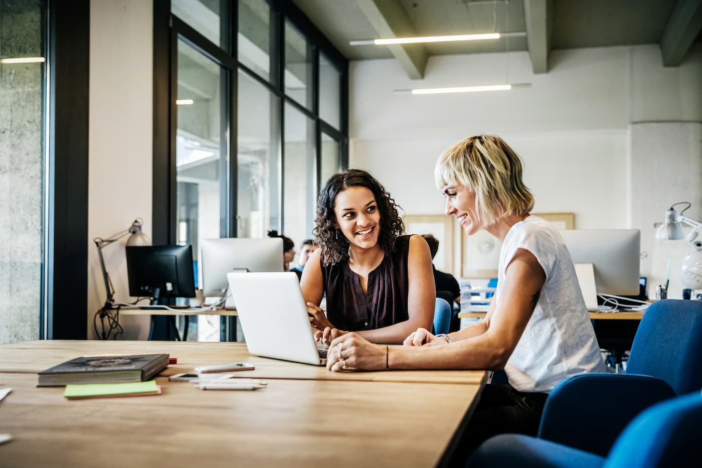 Two women sitting working together in a corporate office