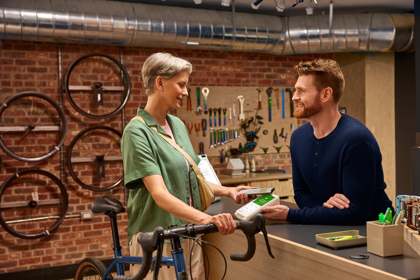 Woman in a bike store making payment on a Clover Flex POS device