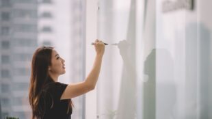 Woman writing on an idea board