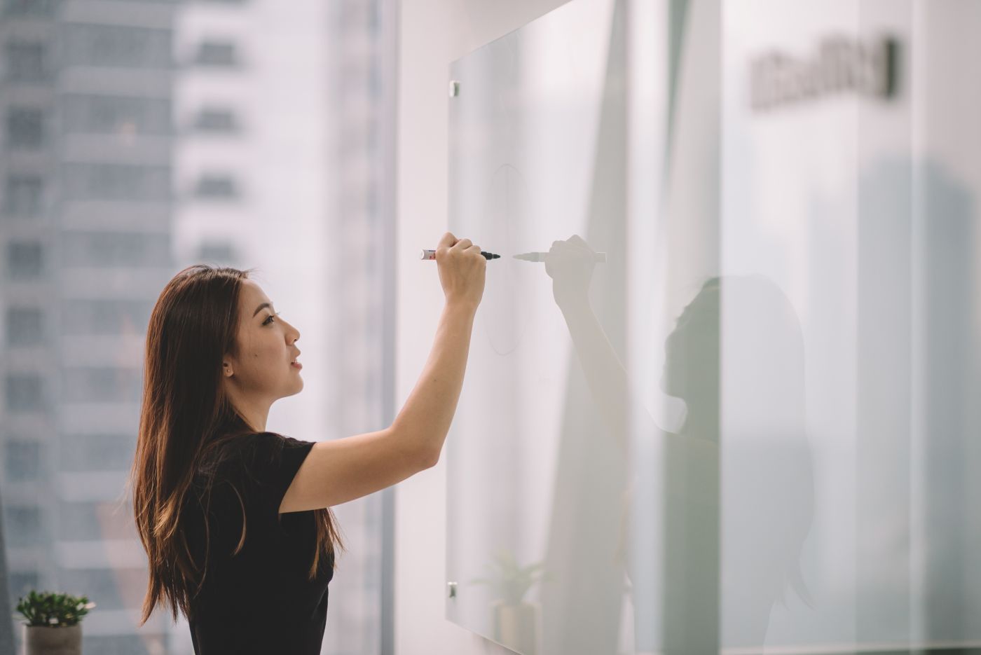 Woman writing on an idea board