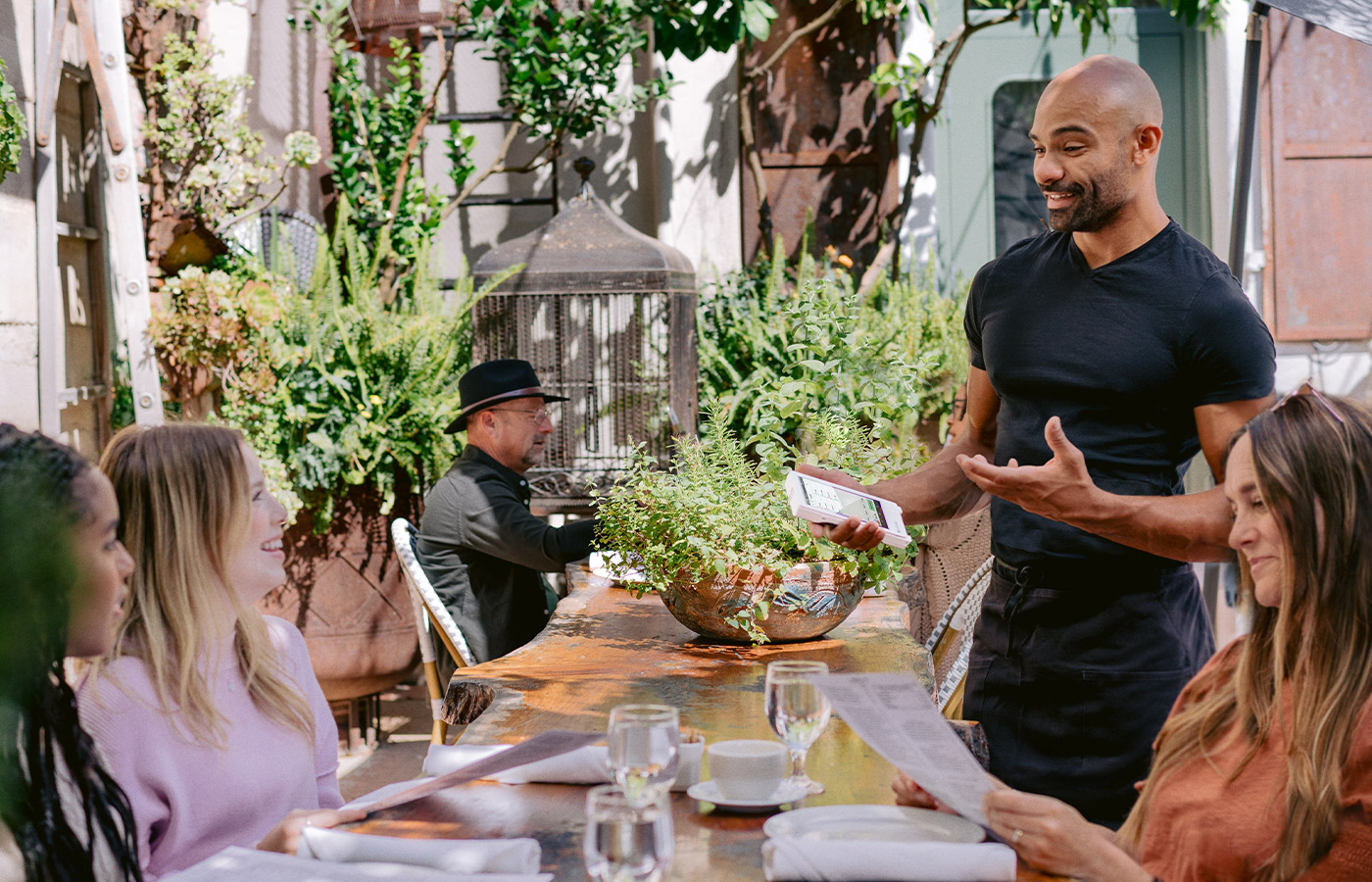 Restaurant server taking a tableside order on an outdoor patio