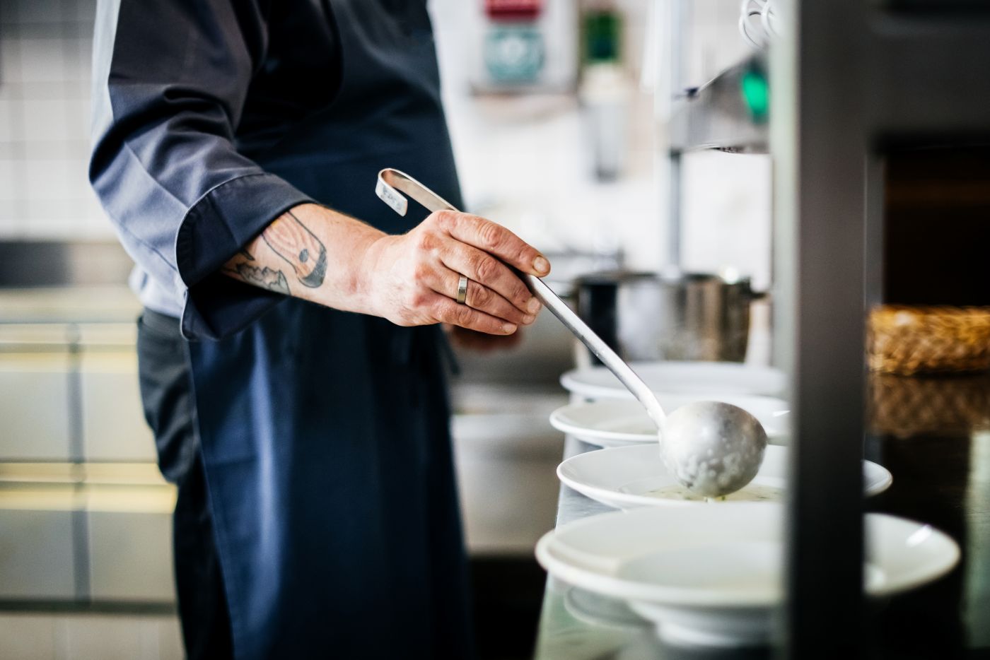 Chef serving bowls of soup in a restaurant kitchen