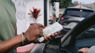Man taking mobile payment in a line of cars with a Clover Flex
