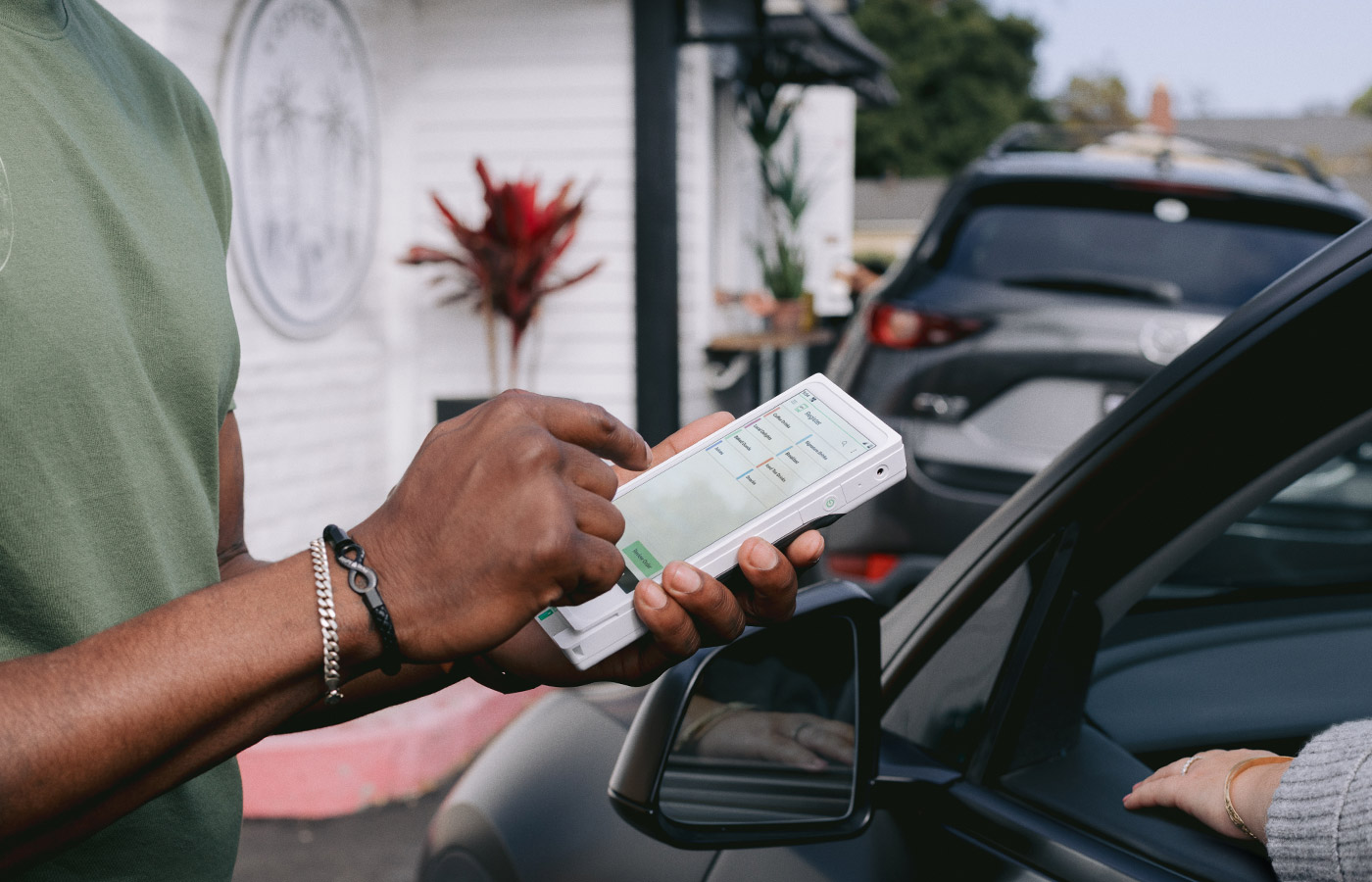 Man taking mobile payment in a line of cars with a Clover Flex