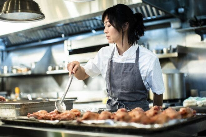 Female chef cooking chicken