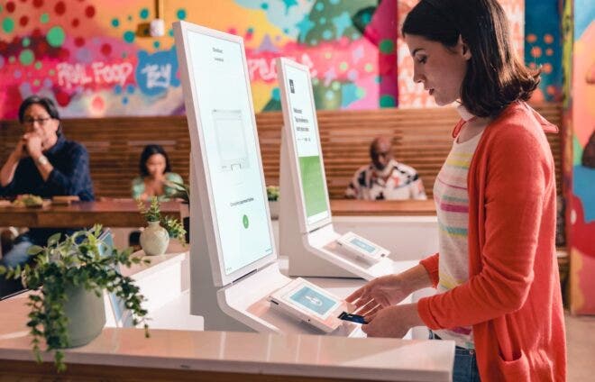 Woman paying for order at Clover Kiosk