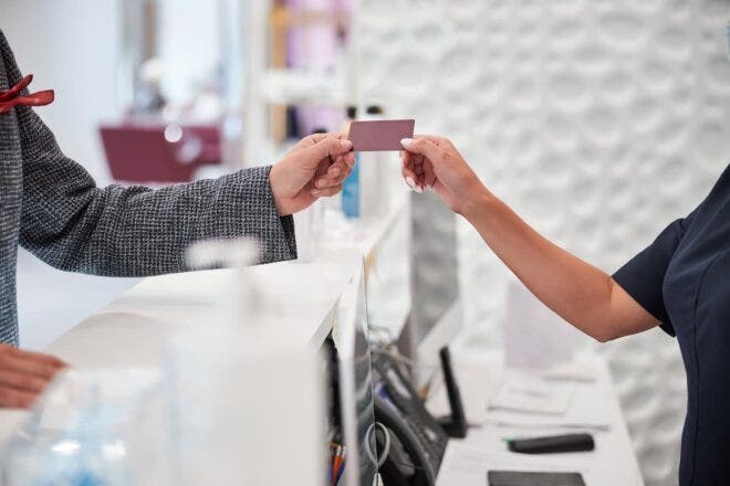 Cashier and client exchanging a gift card