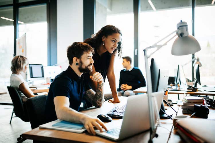 Co-workers looking at computer