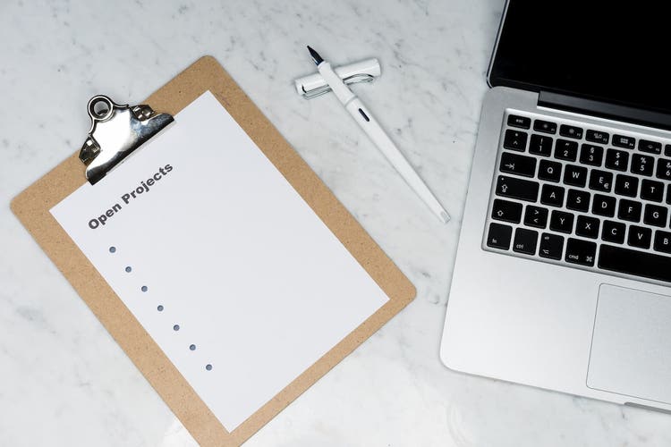 Clipboard next to a laptop