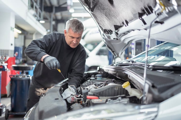 Car mechanic checking under the hood