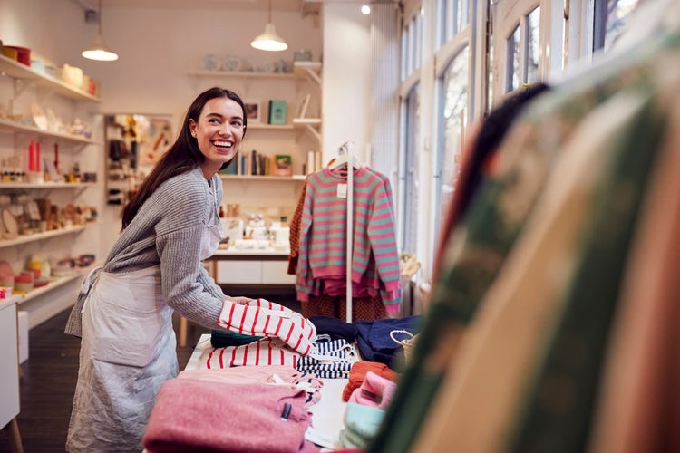 Retail employee folding shirts for display