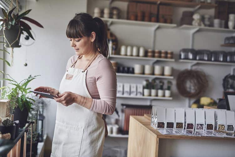 Retail shop owner looking at tablet