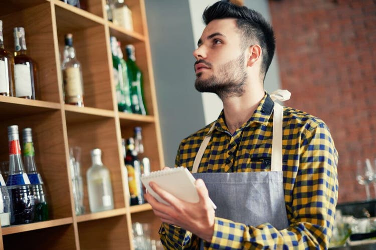 Bartender taking inventory on notepad