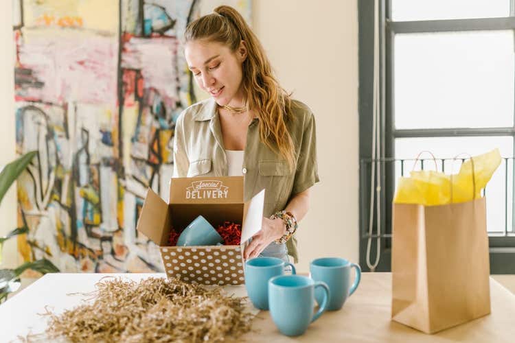 Woman holding cute box with turquoise mug