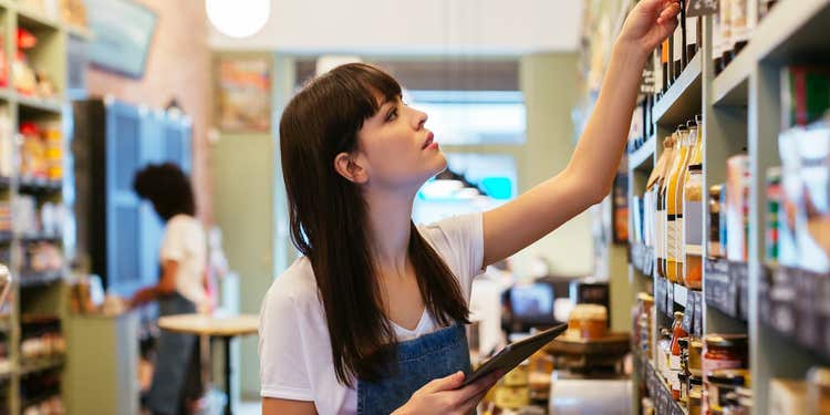 Retail shop worker checking inventory on shelves