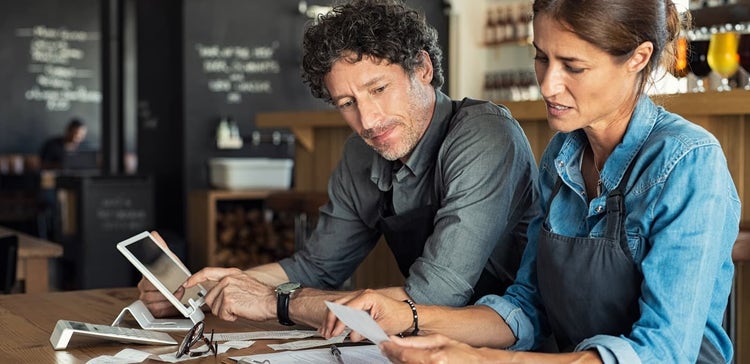 Restaurant owners looking at receipts