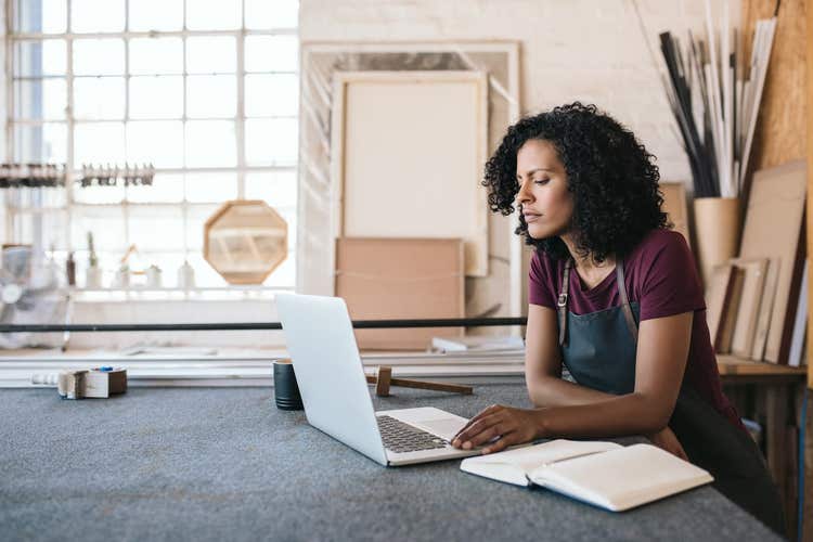 Woman looking at laptop in framing shop