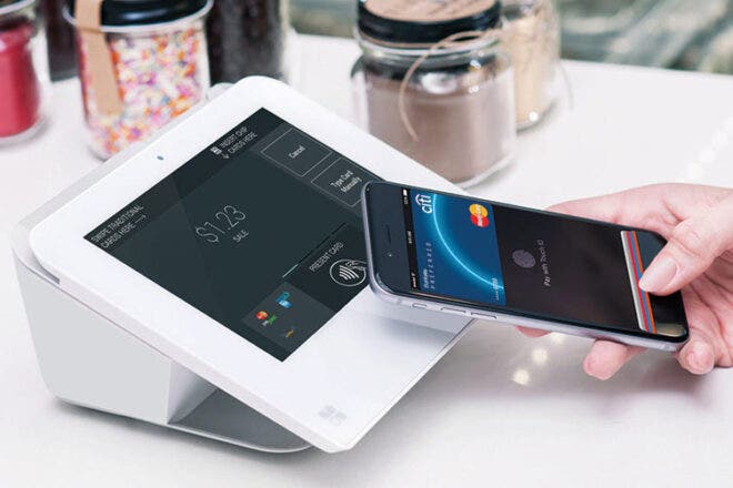 Customer using iPhone to make an NFC payment on a Clover Mini.