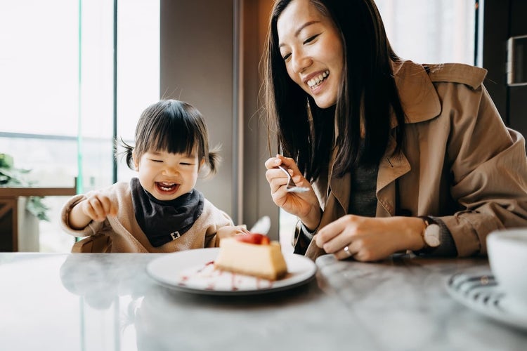 mother and child eating cheesecake at restaurant
