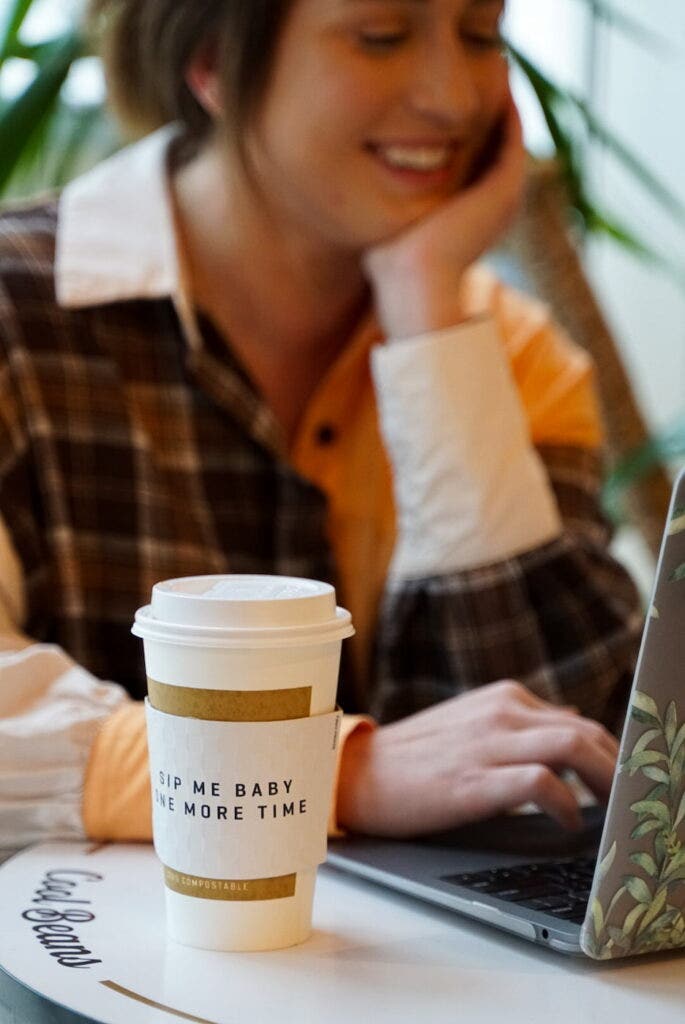 woman at laptop with cup of winfield street coffee