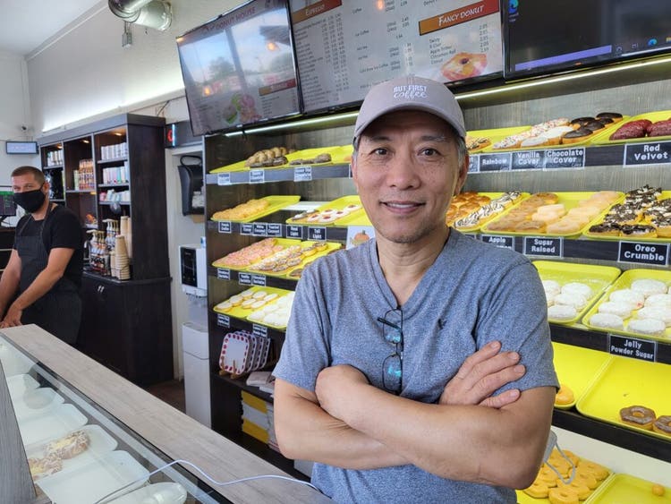 Dae-Kun Kim in front of donut case
