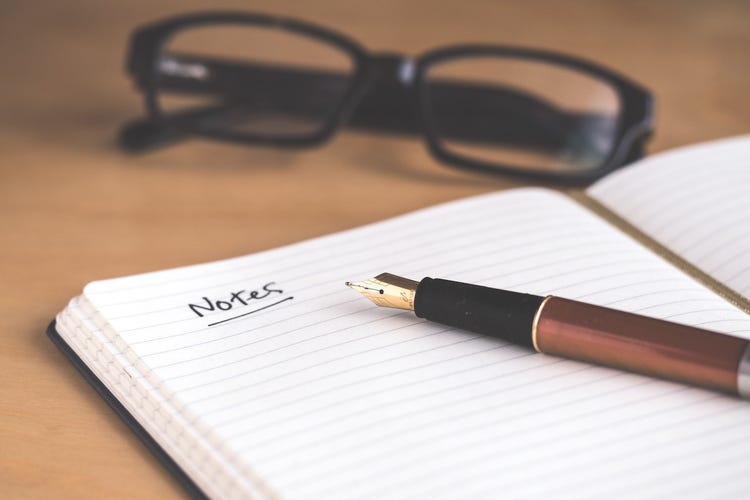 Glasses, pen, and notebook