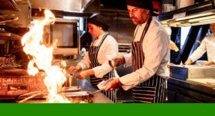 Chefs cooking on a flaming range.