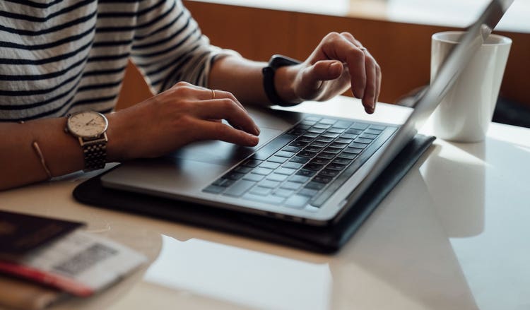 Hands typing on a laptop keyboard