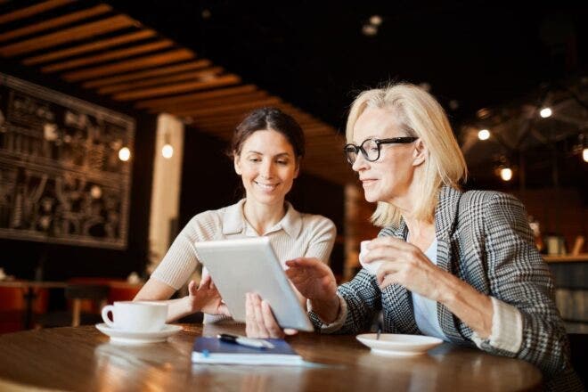 Manager looking at tablet with employee